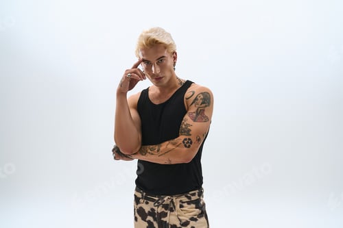 Preview: Young man showcases modern style with confidence and artistic flair in minimalist setting