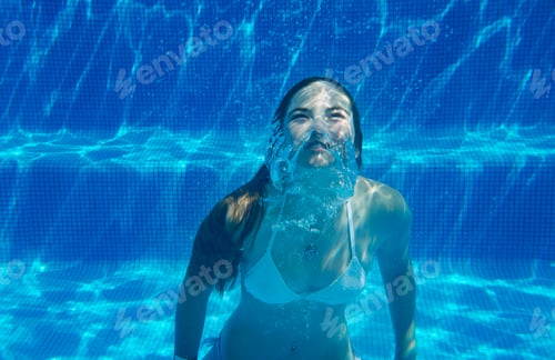 Preview: Underwater view of girl underwater swimming in swimming pool