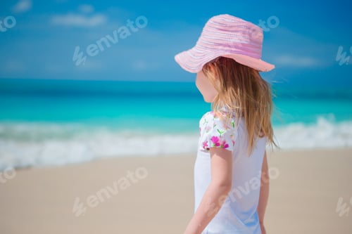 Preview: Adorable little girl walking along white sand Caribbean beach
