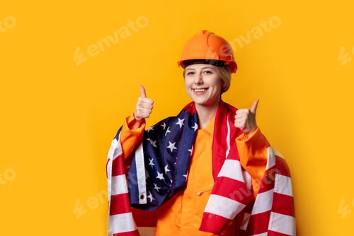 Preview: woman construction worker in helmet and orange overalls with USA flag