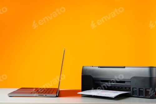 Preview: Laser printer on desk against yellow background.