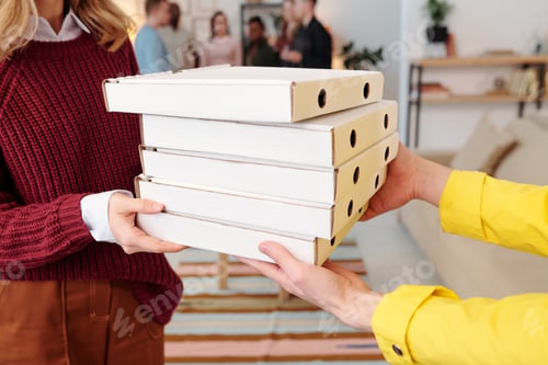 Preview: Young smiling blond female in smart casualwear taking stack of packed pizza