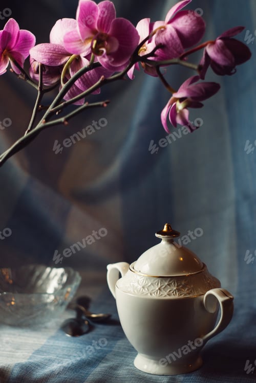 Preview: Home still life of a tea party on the background of an orchid