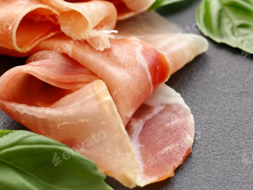Preview: prosciutto ham on a board with basil