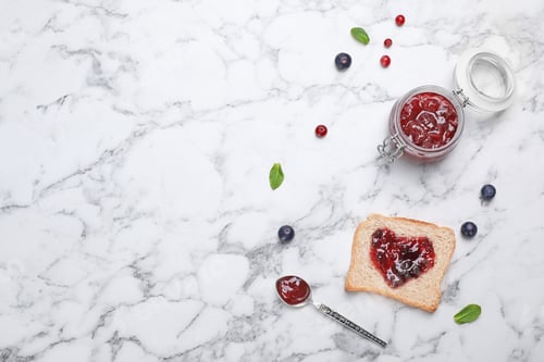 Preview: Toast with jam and berries on light background, top view