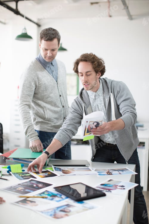 Preview: Young man showing plans to colleagues on meeting in creative office