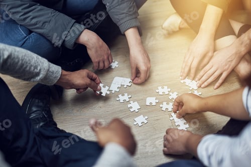 Preview: Start small and grow. Shot of a group of people building a puzzle together.
