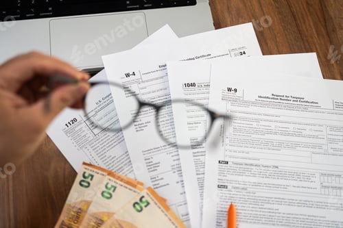 Preview: Man company accountant hand holds glasses preparing for reporting annual income by filling tax forms