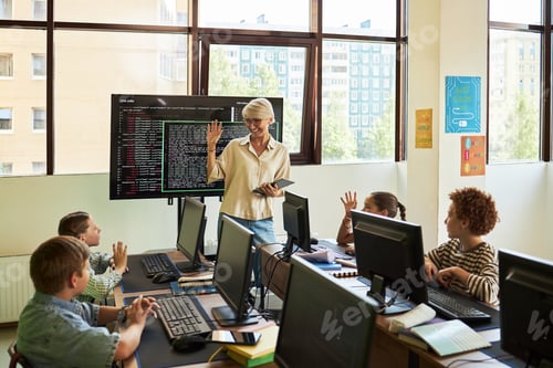 Preview: Caucasian Senior Woman Teaching Group of Diverse Children in Computer Classroom