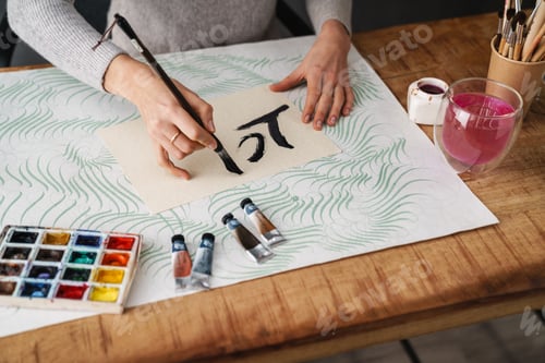 Preview: Calligrapher girl writing while working on valentines at table indoors