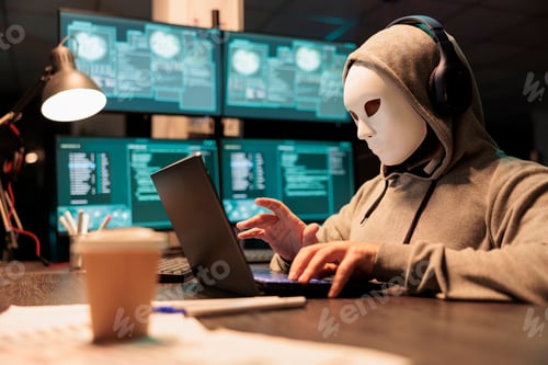 Preview: Hacker with mask and hood breaking security server