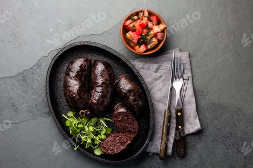 Preview: Bloody sausages - chilean preta on iron plate, top view, grey slate background