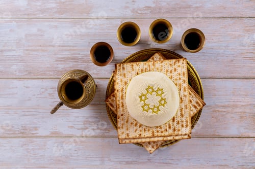 Preview: Matzoh jewish passover bread in the traditional seder plate with kipah over wooden table