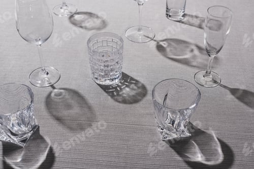 Preview: High angle view of transparent glasses with shadow on grey tablecloth