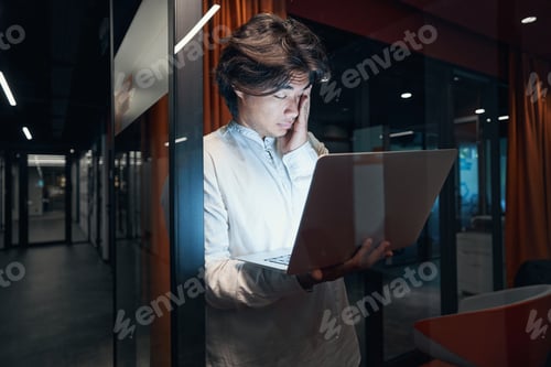 Preview: Male person working over time in office