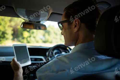 Preview: Man using digital tablet in car