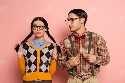 Preview: couple of confused nerds in eyeglasses on pink