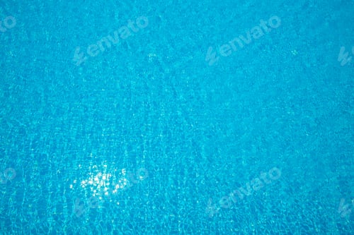 Preview: Bright sparkling blue water in a pool reflecting sunlight on a clear day