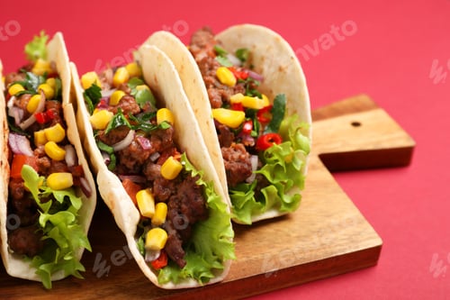 Preview: Delicious tacos with meat and vegetables on red table, closeup