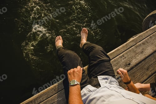 Preview: Male tourist refreshing his feet in the sea water, grain film added.