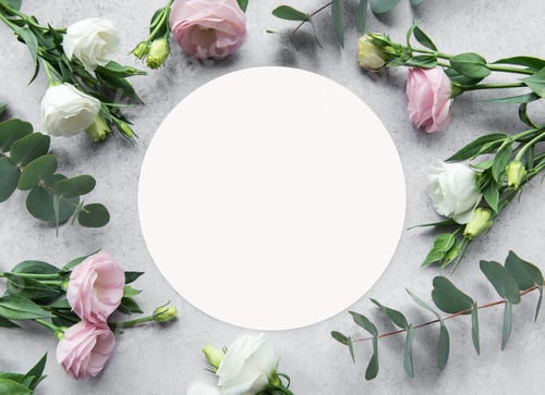 Preview: Delicate arrangement of pink and white flowers surrounding a blank circle on a textured surface