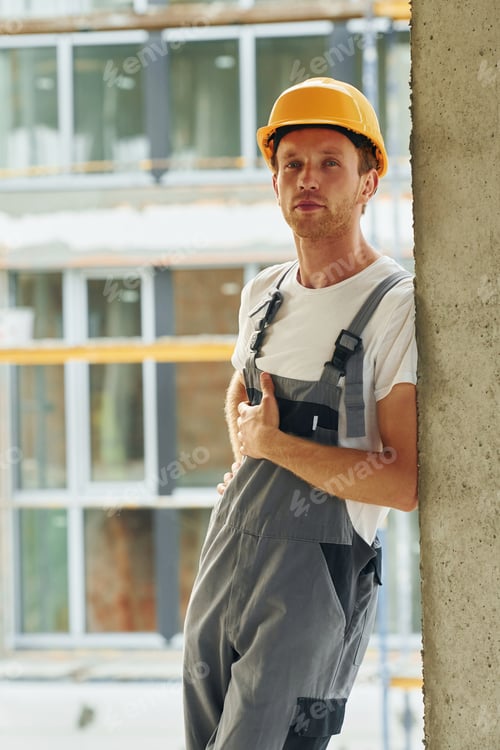 Preview: Indoors in the room. Young man working in uniform at construction at daytime