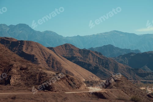 Preview: Picturesque desert mountain landscape featuring a meandering road winding through its terrain