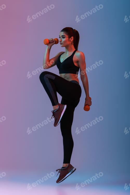 Preview: Full length portrait of sportswoman in tracksuit doing exercises