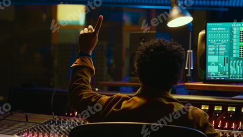 Preview: African american audio engineer counting down singer in sound booth