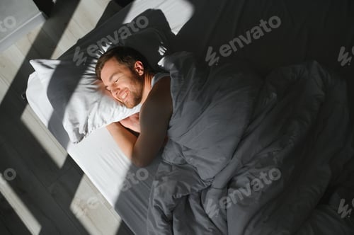 Preview: Cute young man sleeping on bed