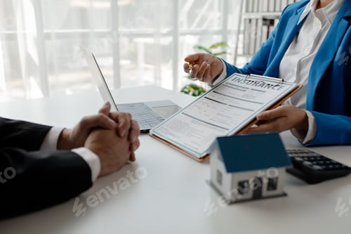 Preview: House insurance paperwork, A realtor is explaining home insurance documents to a buyer in his office