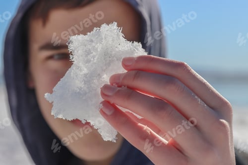 Teen with Frozen Chunk of Snow in Hand