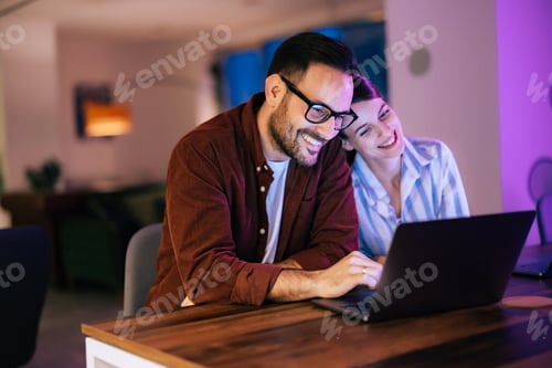 Preview: Happy business colleagues, taking a work break, using the laptop, sitting at the office.