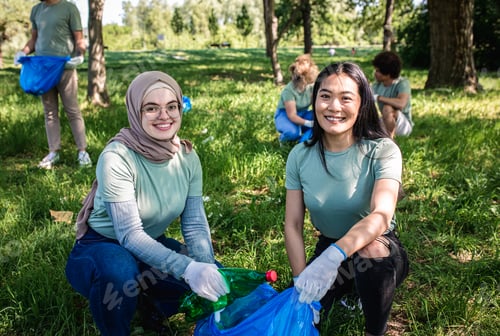 Preview: Multiethnic group of volunteers with garbage bags cleaning city park.