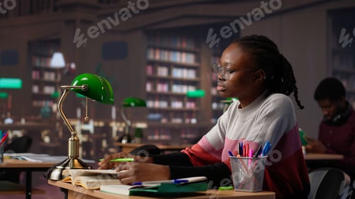 Preview: University student engrossed in texting with classmates at the library
