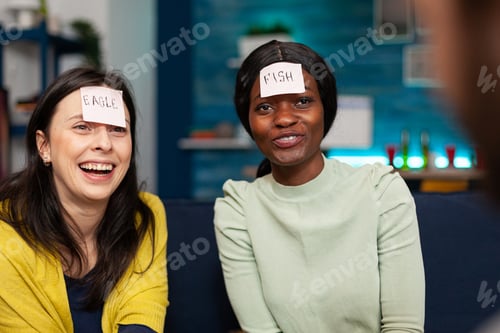 Preview: Multiracial friends enjoying friendship while playing guess who game