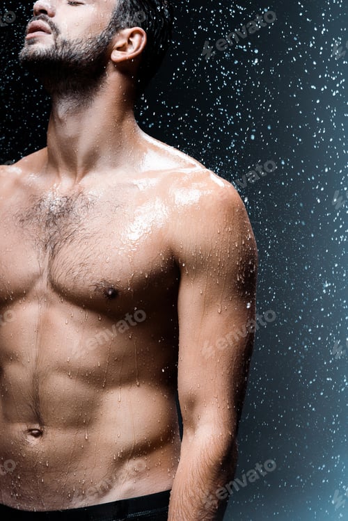 Preview: cropped view of shirtless sexy man standing under raindrops on black