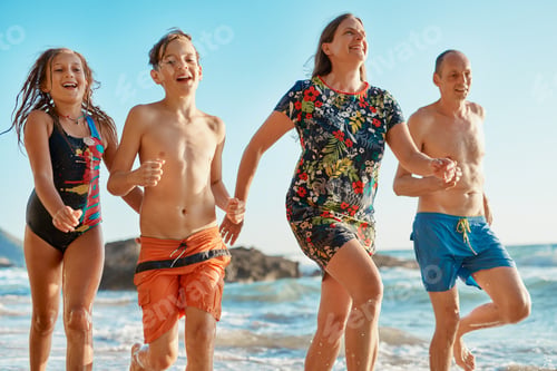 Preview: Winner gets the biggest ice cream. Shot of a family of four running together on the beach.