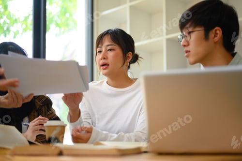 Preview: Group of students sharing ideas with each other while working together in university library