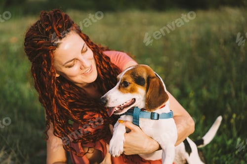 Preview: Beautiful woman plays with her Jack Russell dog in the park.