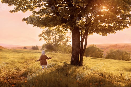 Preview: Tiny Humans Big World. The child is standing near a large tree.