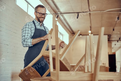 Preview: Cheerful man preparing chairs for customers in cafe
