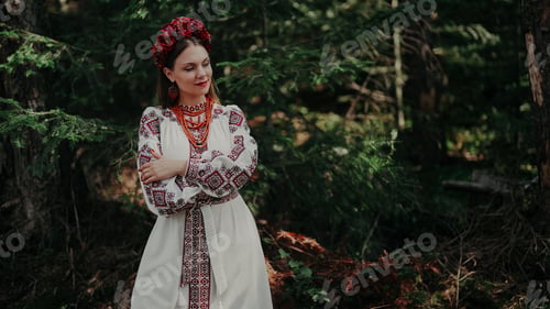 Preview: Pretty woman in traditional ukrainian necklace, dress on green nature backdrop.