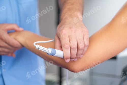 Preview: A physical therapist uses laser therapy on a patients elbow