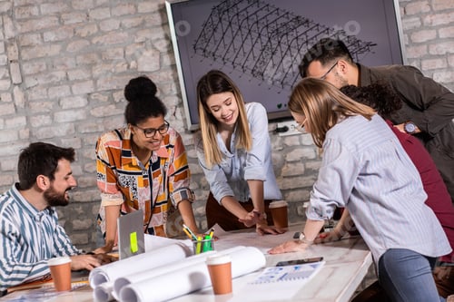 Preview: Group of modern business people discussing architectural designs in the creative office.