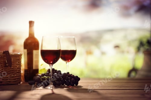 Preview: Red wine bottle and glass on table in vineyard Tuscany Italy