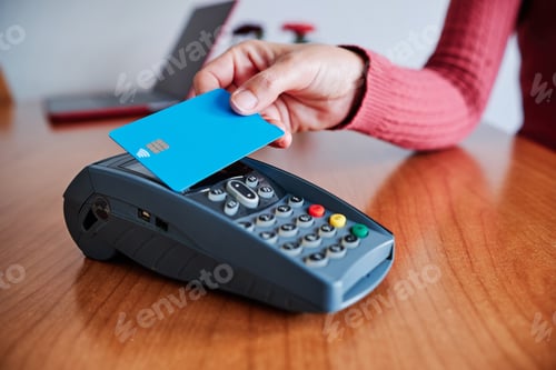 Preview: woman's hand paying with credit card on contactless device