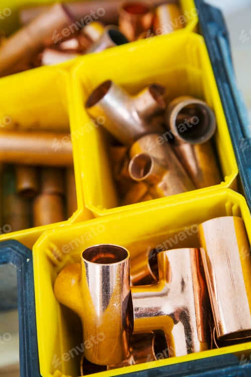 Preview: Close up of plastic boxes with parts of copper pipe.
