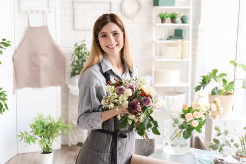 Preview: Female florist with beautiful bouquet at workplace