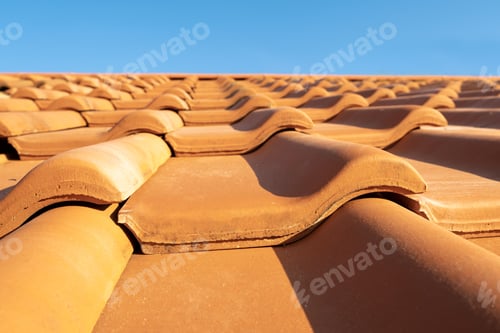 Preview: Overlapping rows of yellow ceramic roofing tiles covering residential building roof